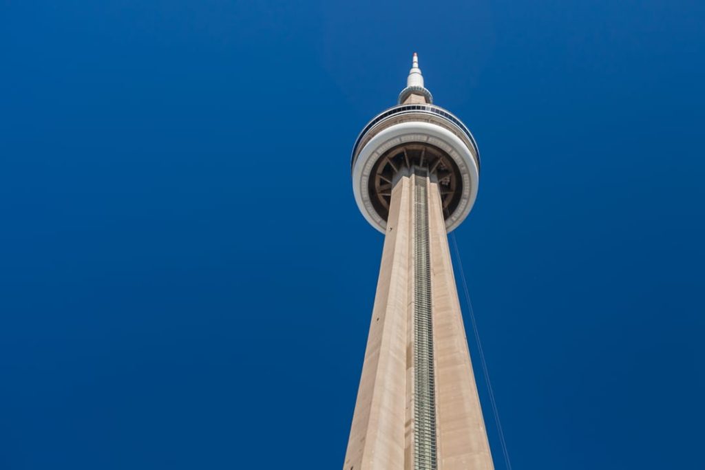 De CN Tower steekt hoog boven de stad uit tegen een strakblauwe onbewolkte hemel in Toronto