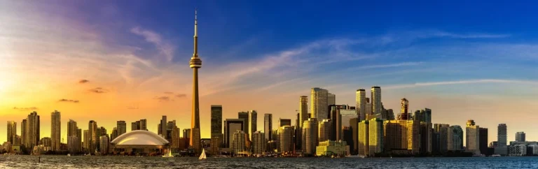 Middeleeuws ogend kasteel met torens in Toronto, verlicht door de avondzon, met oranje en paarse tulpen op de voorgrond