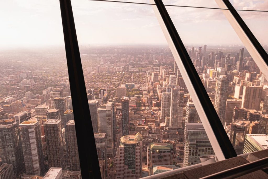 Uitzicht door de glazen wanden van de CN Tower over de wolkenkrabbers en straten van Toronto