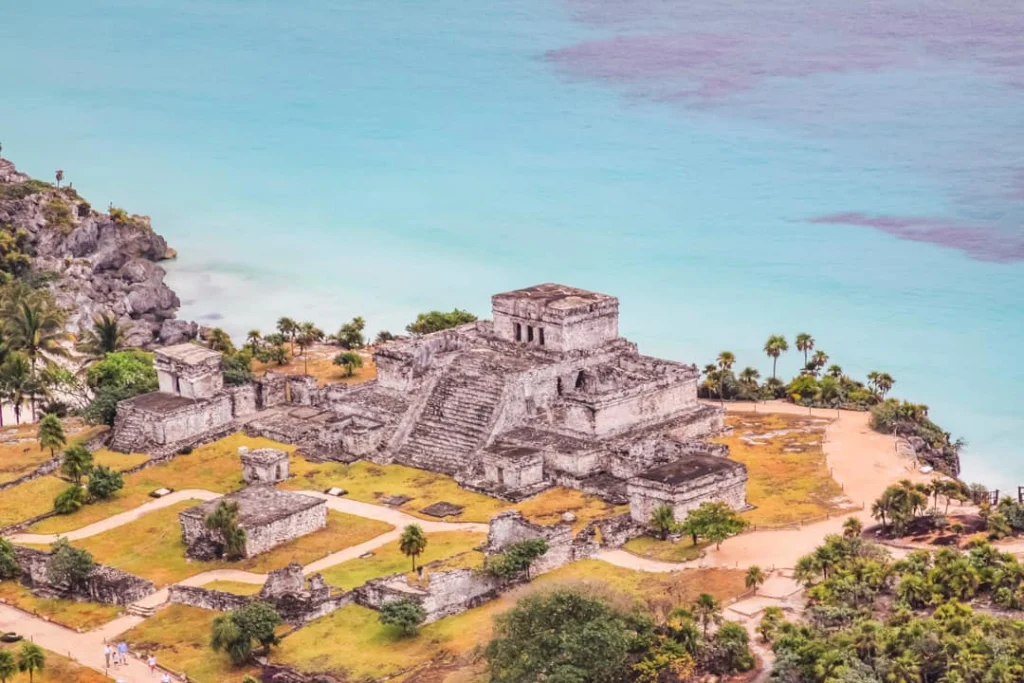 Luchtfoto van de tempelruïne El Castillo in Tulum, gelegen op de rots tussen groene jungle en turquoise zee