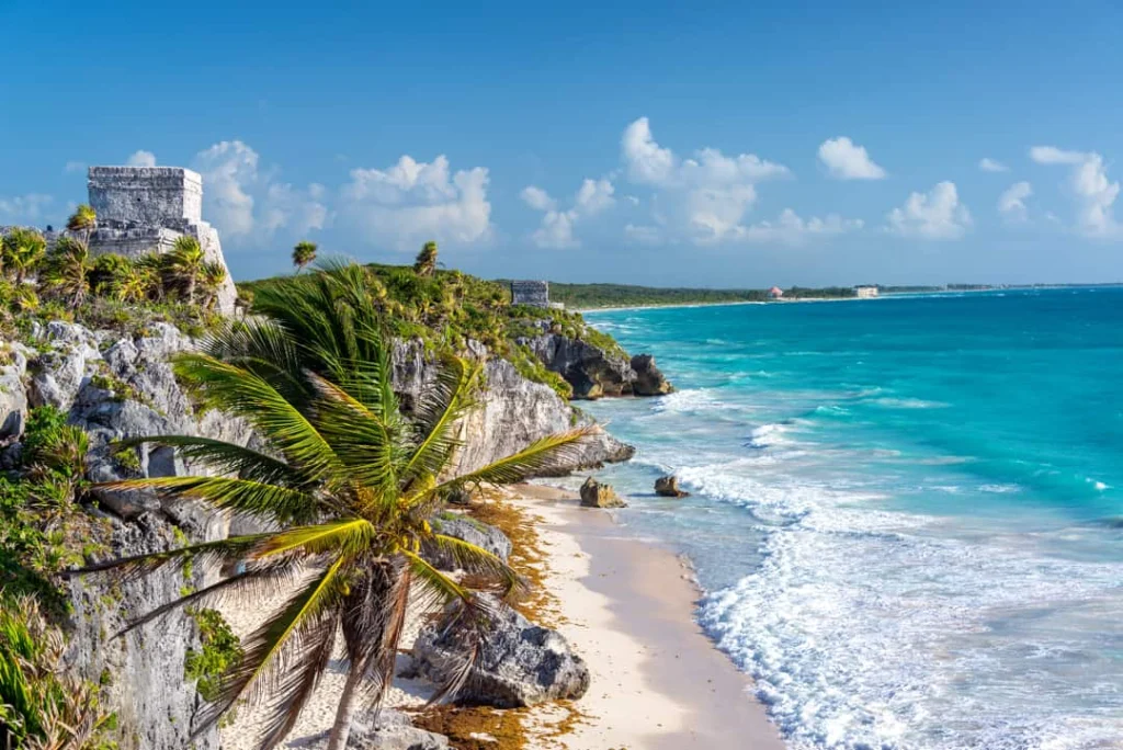 Luchtfoto van de stenen ruïnes van Tulum op de rotsen boven een strand met turquoise zee