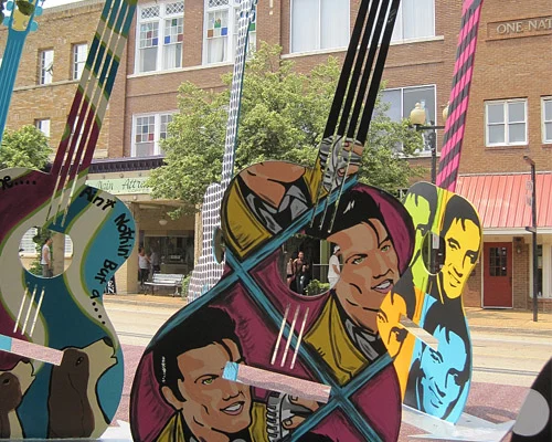 Grote gitaarvormige kunstwerken beschilderd met portretten van Elvis Presley opgesteld op straat in zijn geboorteplaats Tupelo in Mississippi