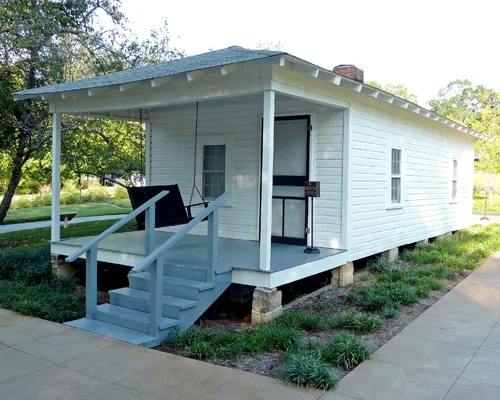 Klein wit houten huisje met veranda en een schommel, het geboortehuis van Elvis Presley in Tupelo in Mississippi