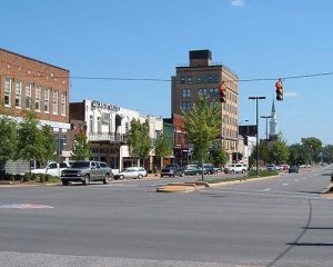 Rustig kruispunt met verkeerslichten, geparkeerde auto's en historische winkelpanden in het centrum van een stad in Alabama