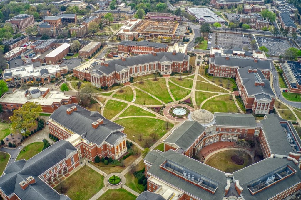 Luchtfoto van bakstenen universiteitsgebouwen rond een grasveld met paden op de campus van de University of Alabama