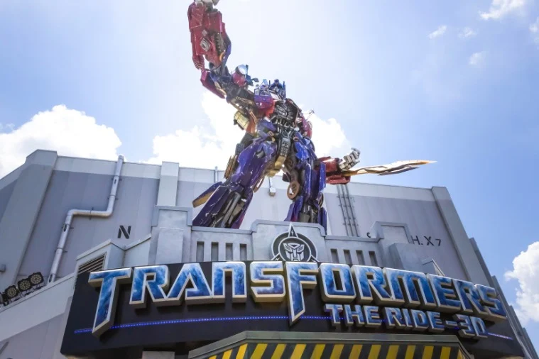 Groot beeld van een robotfiguur boven het opschrift Transformers The Ride aan de gevel van de attractie