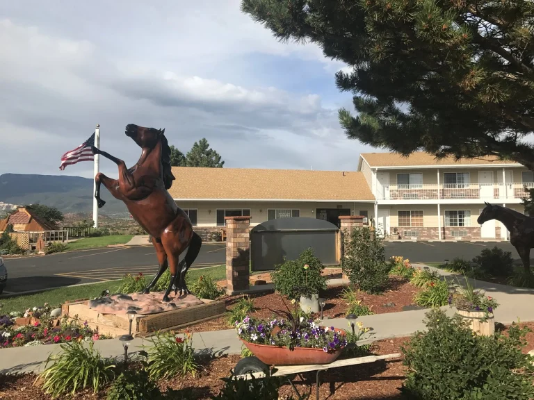 Een bronzen standbeeld van een steigerend paard met Amerikaanse vlag staat in de tuin voor een motel in Utah