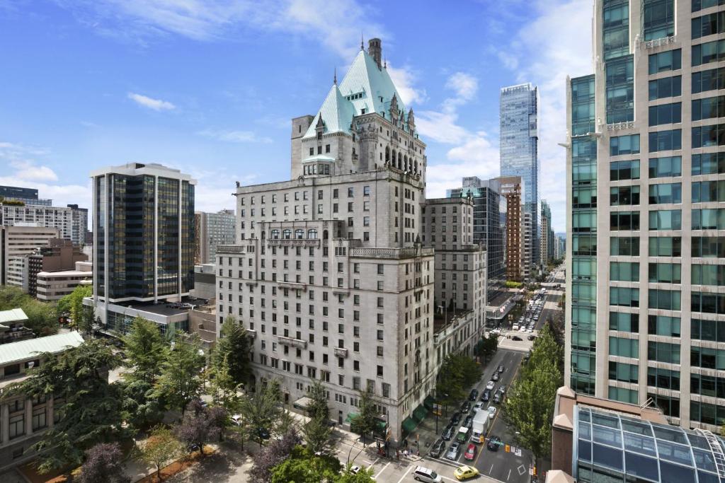 Het kasteelachtige Fairmont Hotel Vancouver met groen koperen dak steekt uit boven de omliggende wolkenkrabbers in de stad