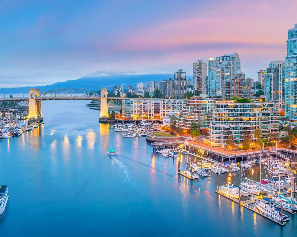 Luchtfoto bij zonsondergang van de jachthaven en wolkenkrabbers van Vancouver rond False Creek met de Burrard Street Bridge op de achtergrond