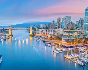 Luchtfoto bij zonsondergang van de jachthaven en wolkenkrabbers van Vancouver rond False Creek met de Burrard Street Bridge op de achtergrond