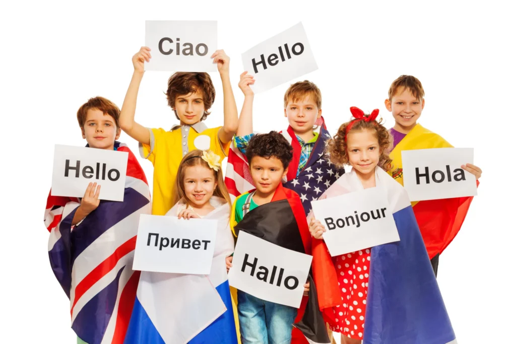Groep kinderen gewikkeld in vlaggen van verschillende landen houdt bordjes omhoog met het woord hallo in hun eigen taal