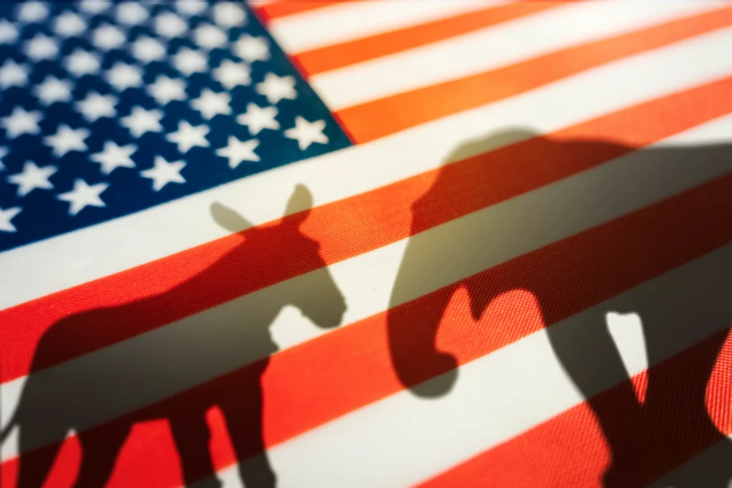 Silhouetten van een ezel en een olifant als symbolen van de Democraten en Republikeinen geprojecteerd op een Amerikaanse vlag