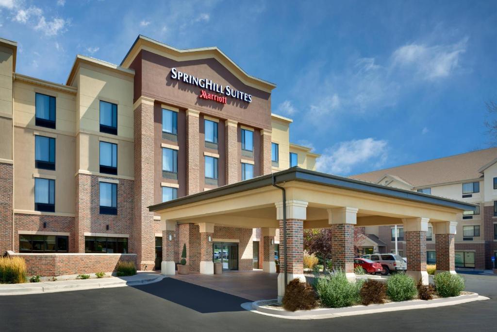 Bakstenen gevel van een hotel van de keten SpringHill Suites Marriott met een overdekte oprit onder een blauwe lucht
