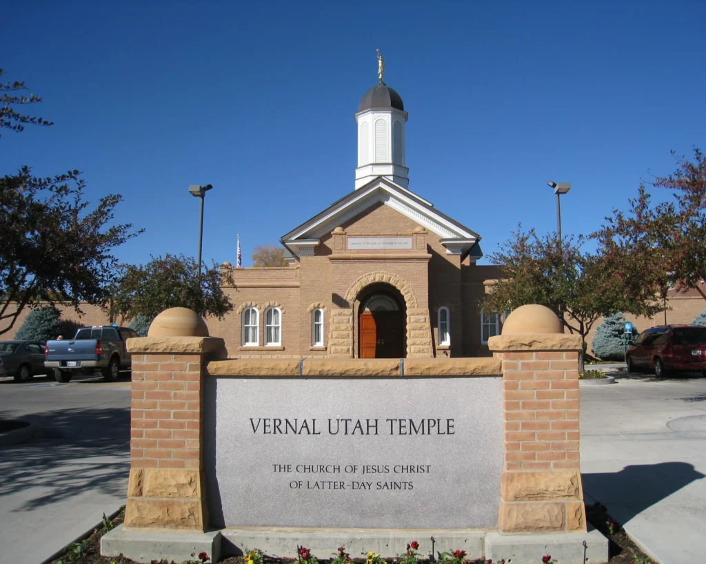 Bakstenen tempelgebouw met witte torenspits van de kerk van Jezus Christus van de Heiligen der Laatste Dagen in Vernal, Utah, onder een strakblauwe lucht