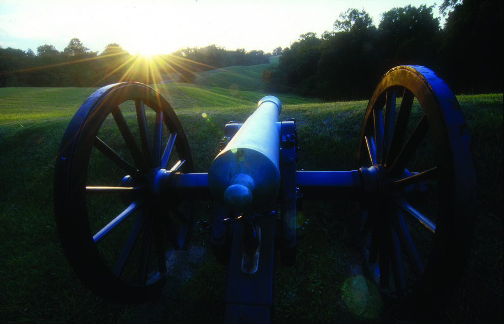 Silhouet van een civil war kanon op een heuvel bij zonsopkomst met glooiend grasland in Vicksburg National Military Park