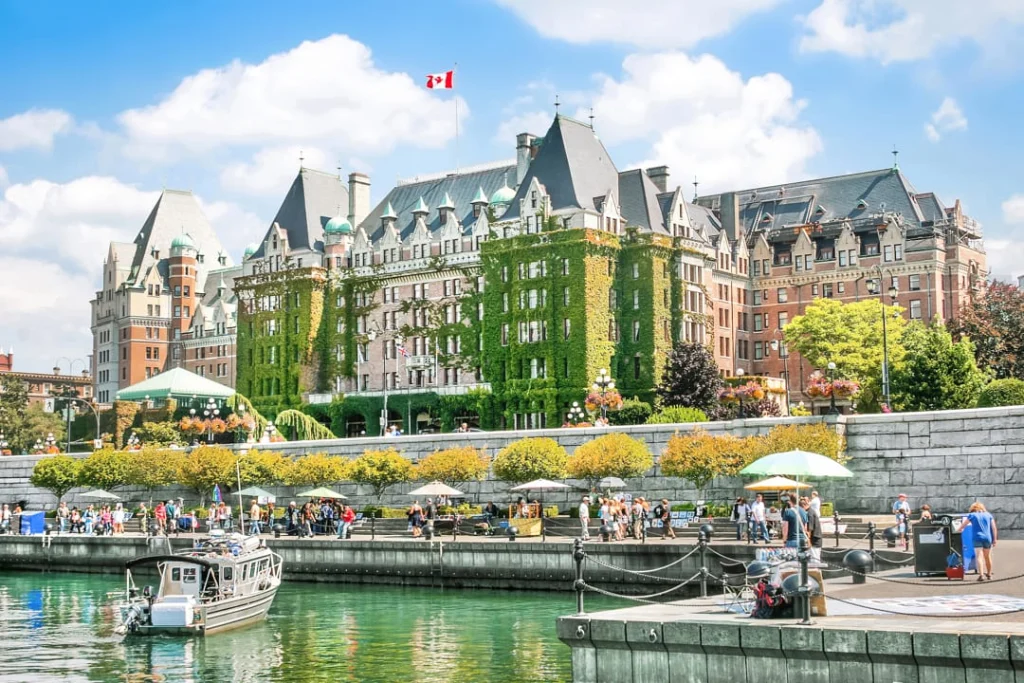 Het imposante met klimop begroeide Fairmont Empress Hotel aan de Inner Harbour van Victoria met bootjes en wandelaars