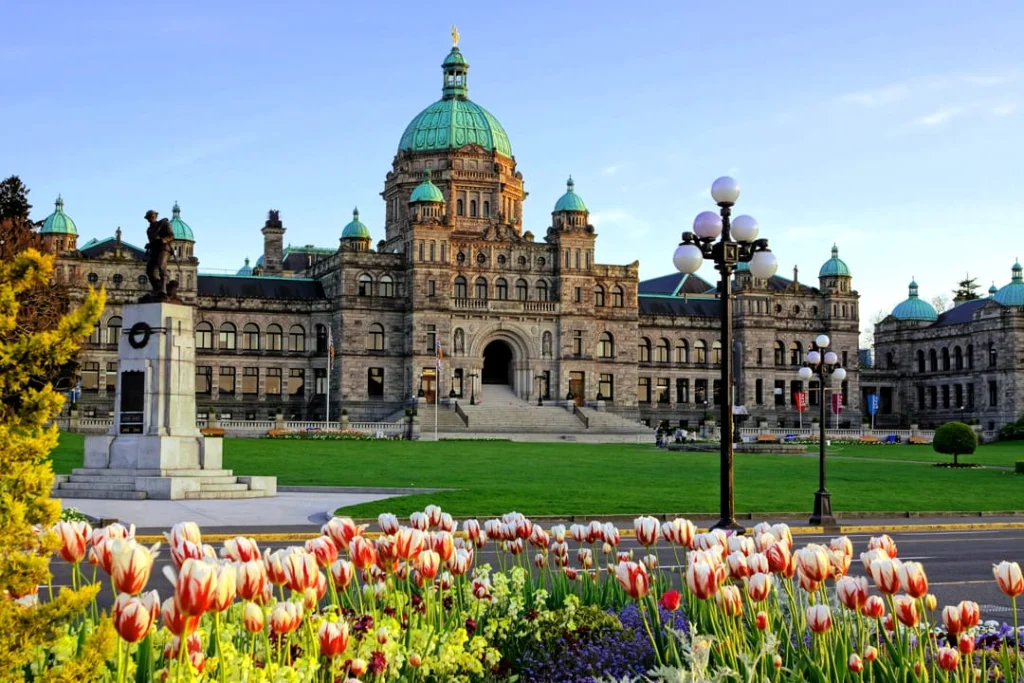 Historisch koepelgebouw van het parlement van British Columbia in Victoria met een bed rode en witte tulpen op de voorgrond