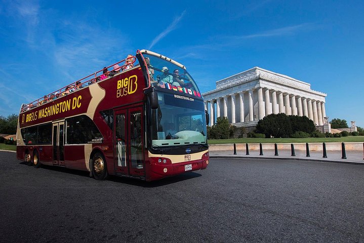 Rode dubbeldekker sightseeingbus met open bovendek staat geparkeerd voor de zuilengevel van het Lincoln Memorial