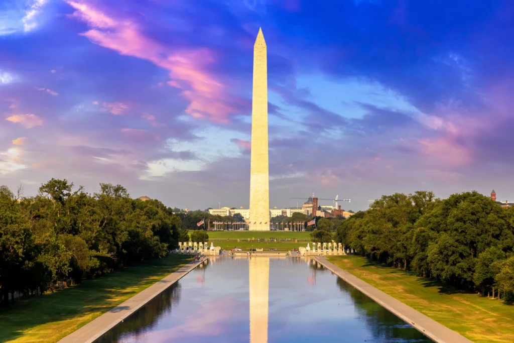 Het Washington Monument weerspiegeld in de reflecting pool met een paars en roze gekleurde lucht in Washington DC