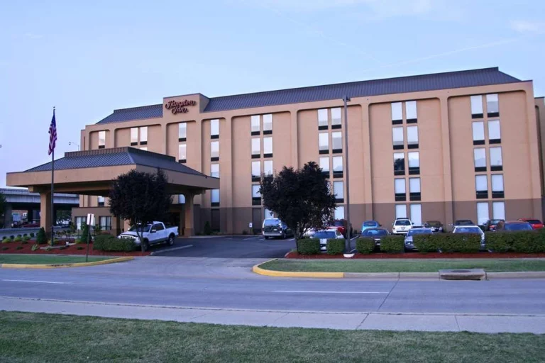 Buitenkant van een Hampton Inn hotel in West Virginia met parkeerplaats en Amerikaanse vlag bij de entree