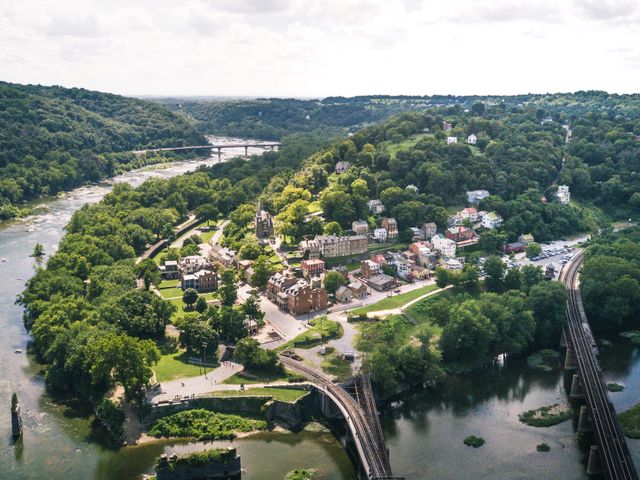 Luchtfoto van een klein stadje in West Virginia, omringd door beboste heuvels en gelegen op de samenvloeiing van twee rivieren met spoorbruggen