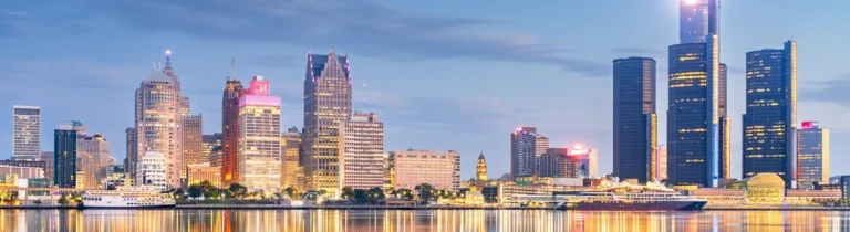 Wolkenkrabbers van Detroit weerspiegelen in het water van de Detroit River gezien vanaf de kant van Windsor bij zonsondergang
