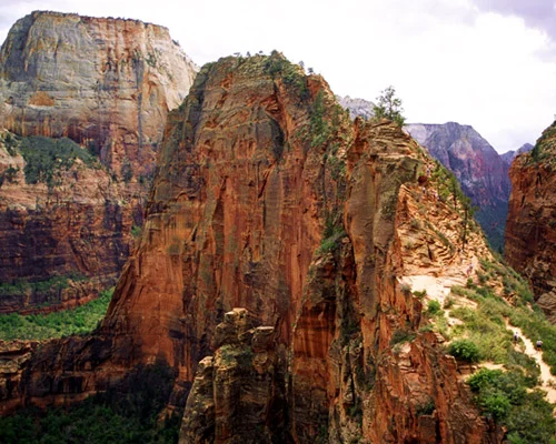 Wandelaars op het smalle pad over de kartelige rotsrug van Angels Landing met steile rode rotswanden aan weerszijden in Zion National Park