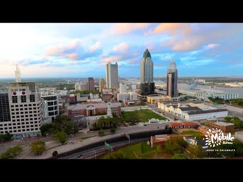 Luchtfoto van de skyline van Mobile in Alabama met wolkenkrabbers en de rivier op de achtergrond bij zonsondergang
