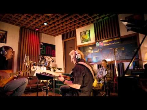 Een band met gitaristen en drummer speelt live in de beroemde opnamestudio Fame in Muscle Shoals
