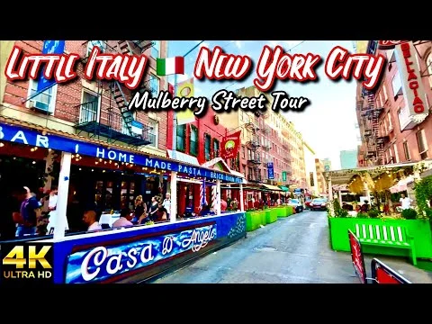 Levendige Mulberry Street in Little Italy in New York met terrassen, restaurants en voetgangers overdag