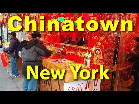 Videostill van een marktkraam met rode Chinese versieringen en decoraties in Chinatown New York, met de tekst Chinatown New York in beeld