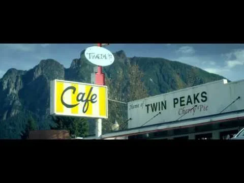Geel bord met de tekst Cafe en een bord Home of Twin Peaks Cherry Pie voor het bekende eetcafe Twede's in North Bend in de staat Washington