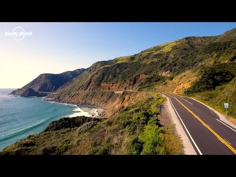 Videothumbnail met een kustweg langs groene kliffen en de oceaan, met het logo van Lonely Planet in de hoek