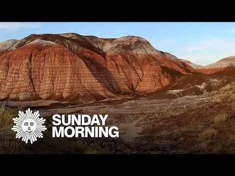 Videominiatuur met een glooiend, roodgekleurd woestijnlandschap van de Painted Desert en het logo van CBS Sunday Morning in beeld