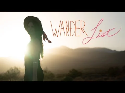 Videothumbnail met een silhouet van een vrouw met hoed in de woestijn bij zonsondergang en het logo van Wander List