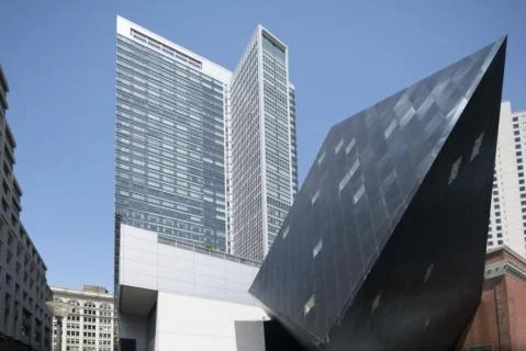 Hoekig zwart gebouw van het Contemporary Jewish Museum met op de achtergrond hoge kantoortorens in San Francisco