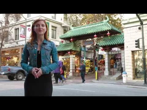 Videothumbnail met een presentatrice die spreekt voor de sierlijke toegangspoort van Chinatown in San Francisco
