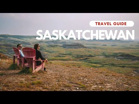 Twee rode stoelen op een heuvel met uitzicht over de badlands van Saskatchewan met tekst van een reisgidsvideo in beeld