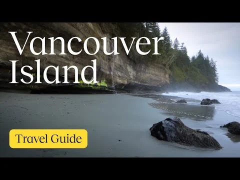 Rotsachtig strand met een hoge begroeide klif en donkere rotsen aan de kust van Vancouver Island
