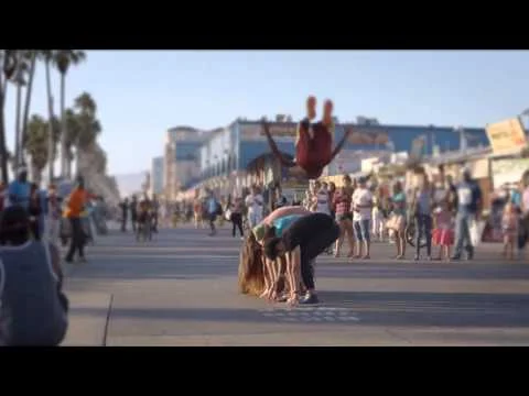 Straatartiest maakt een achterwaartse salto voor publiek op de drukke boulevard van Venice Beach