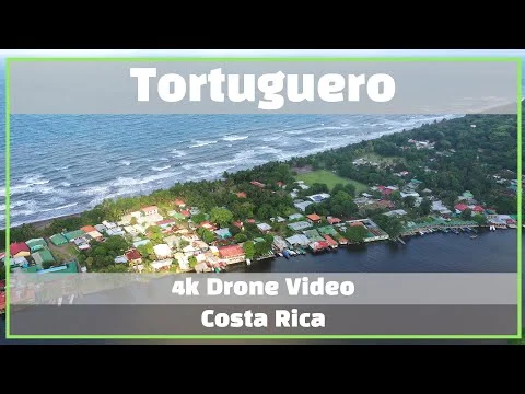 Videominiatuur met de tekst Tortuguero 4k drone video Costa Rica over een luchtfoto van het dorp aan zee