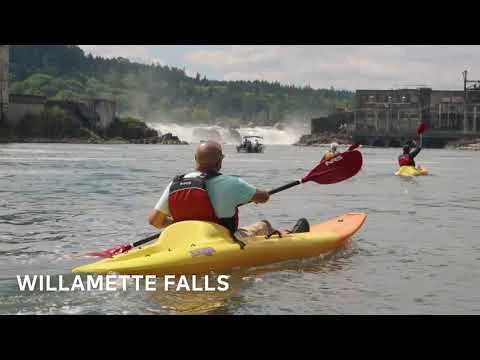 Videothumbnail met de tekst Willamette Falls over een foto van kajakkers op de rivier bij de waterval in Oregon