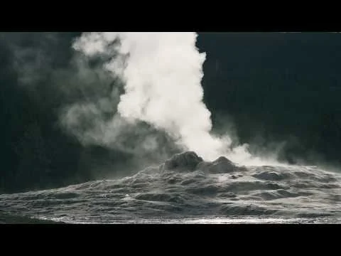 Close-up van kokend water en een hoge kolom stoom tijdens de uitbarsting van een geiser in tegenlicht