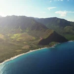 Luchtfoto van groene bergketens en een rustige baai aan de westkust van Oahu, Hawaii, bij zonsopgang