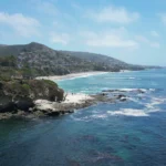 Luchtfoto van villa's op de kliffen boven een baai bij Laguna Beach in Zuid-Californie met zwemmers in het heldere water